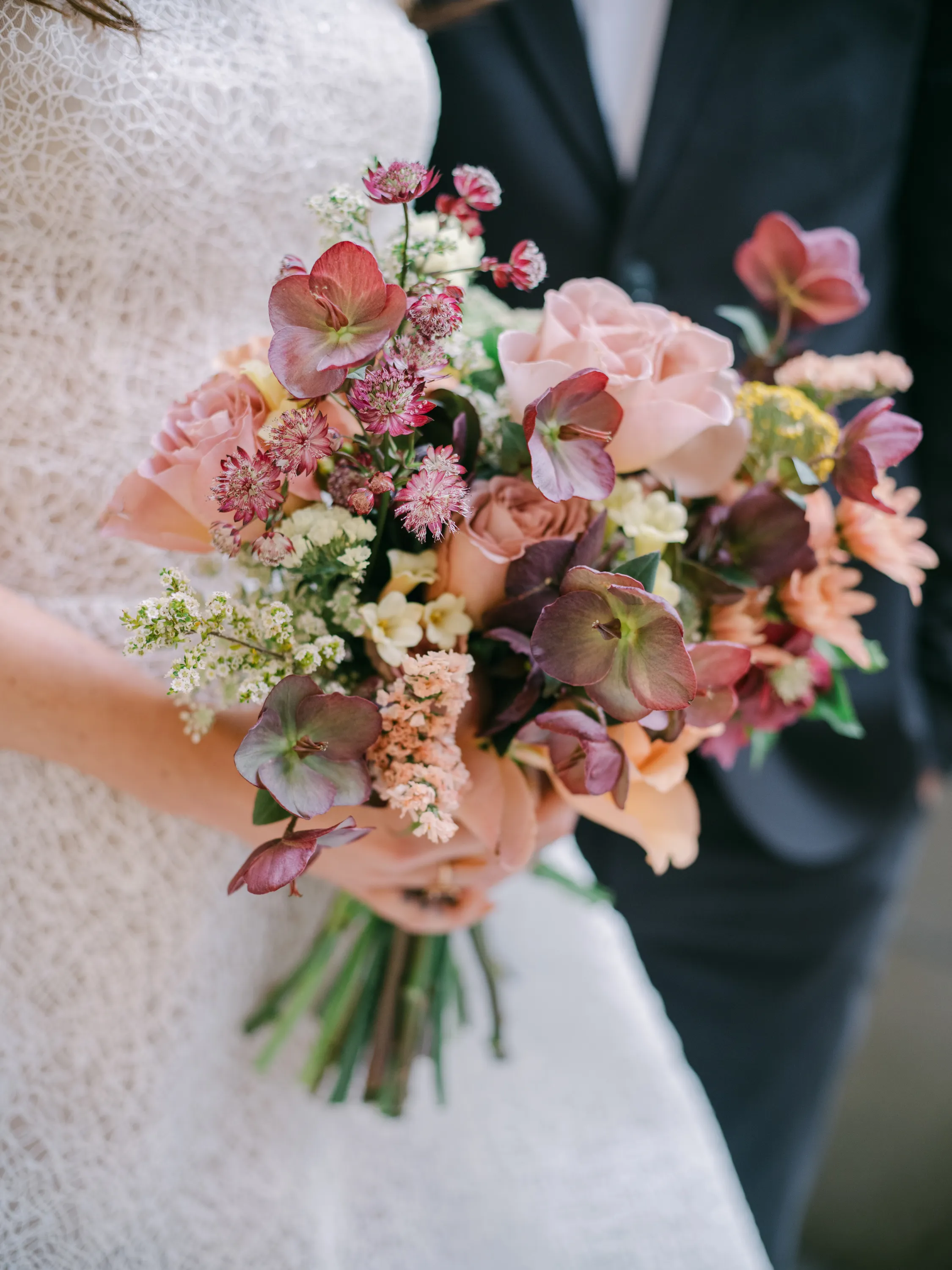 Bride holding a peach, mauve, and gold fall wedding bouquet at The Hythe Vail