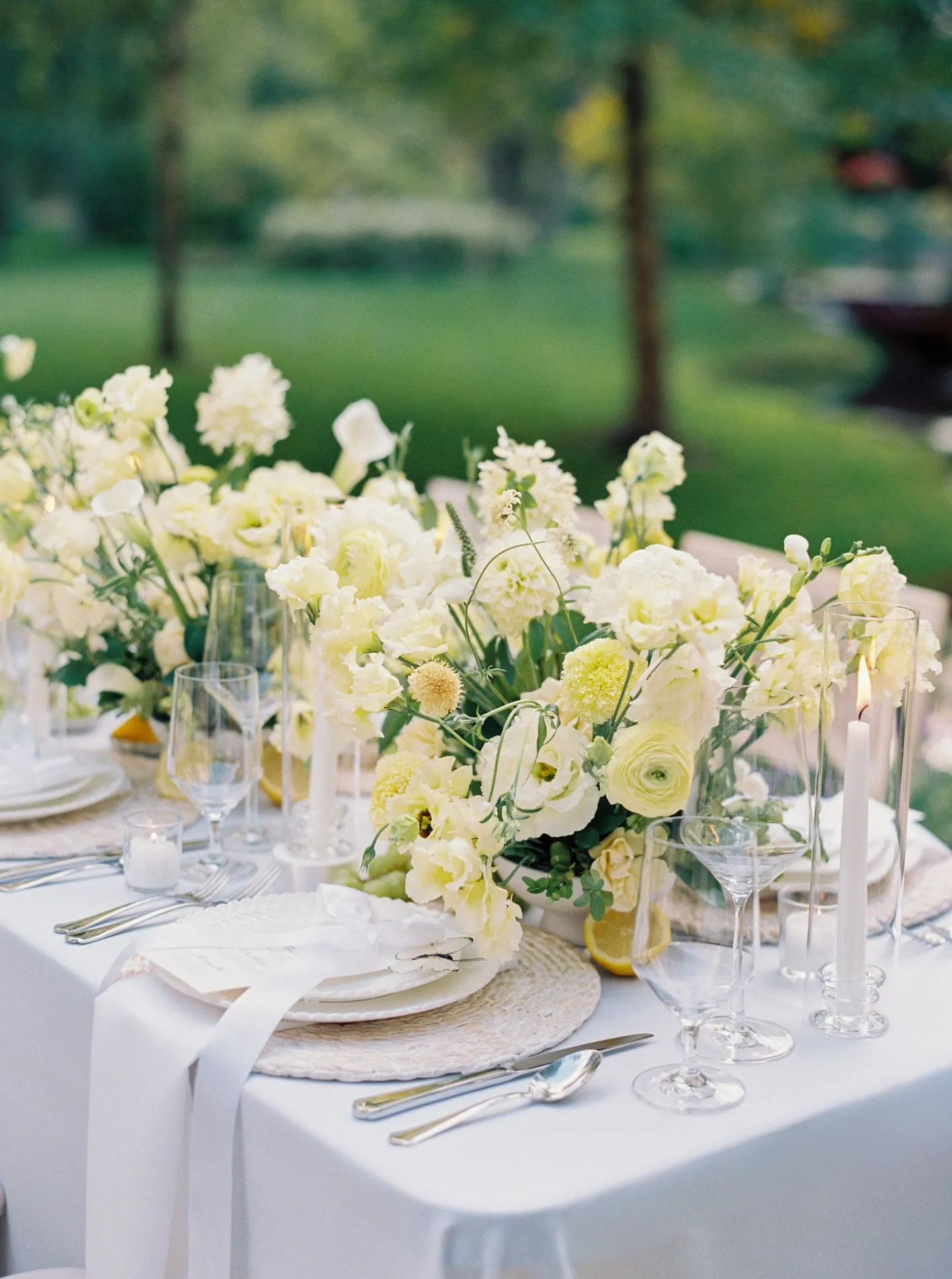 Oceana's Gardens outdoor long dining table with white floral garland and candles