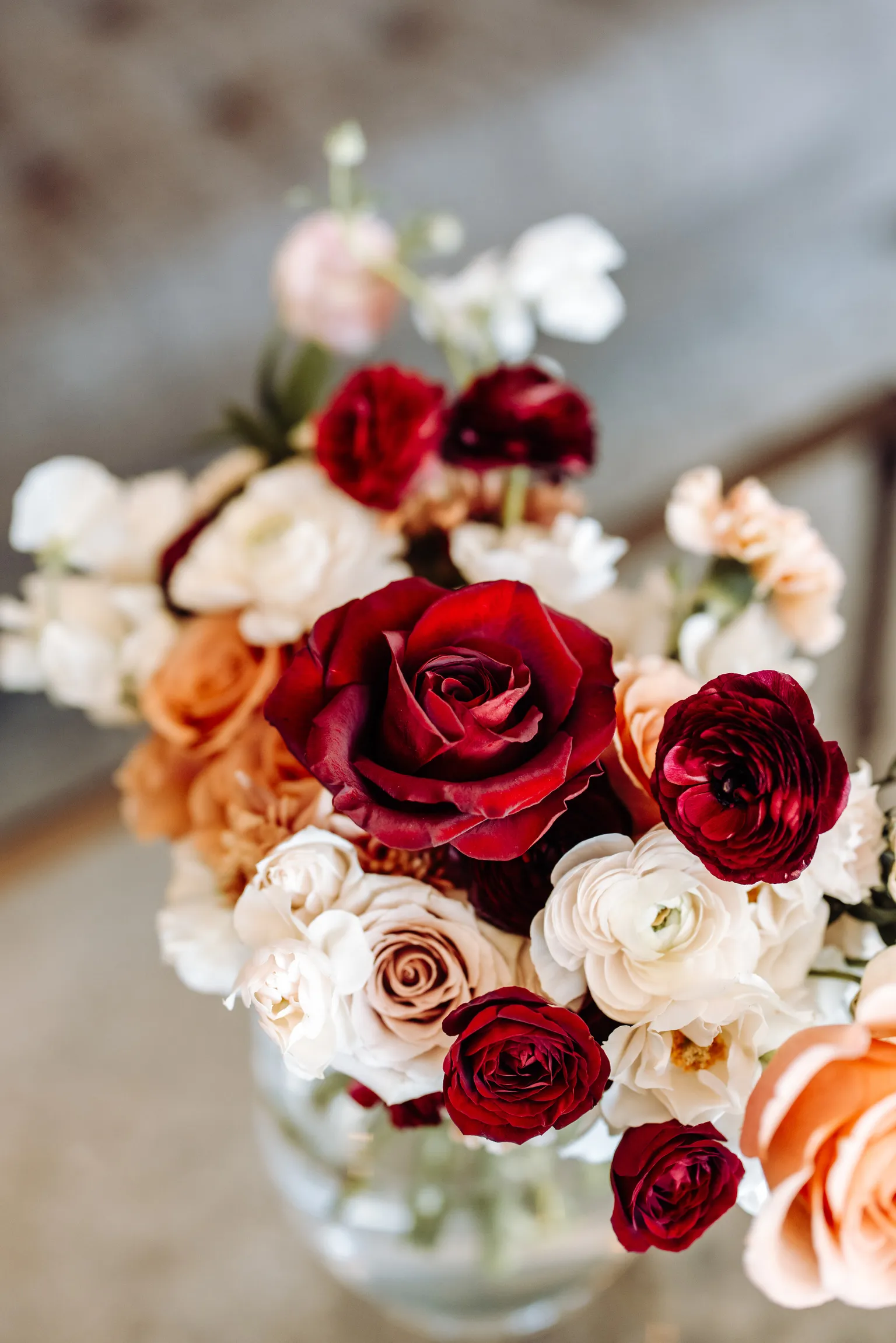 Close-up of a burgundy rose bouquet with terracotta and neutral blooms at The Manor House