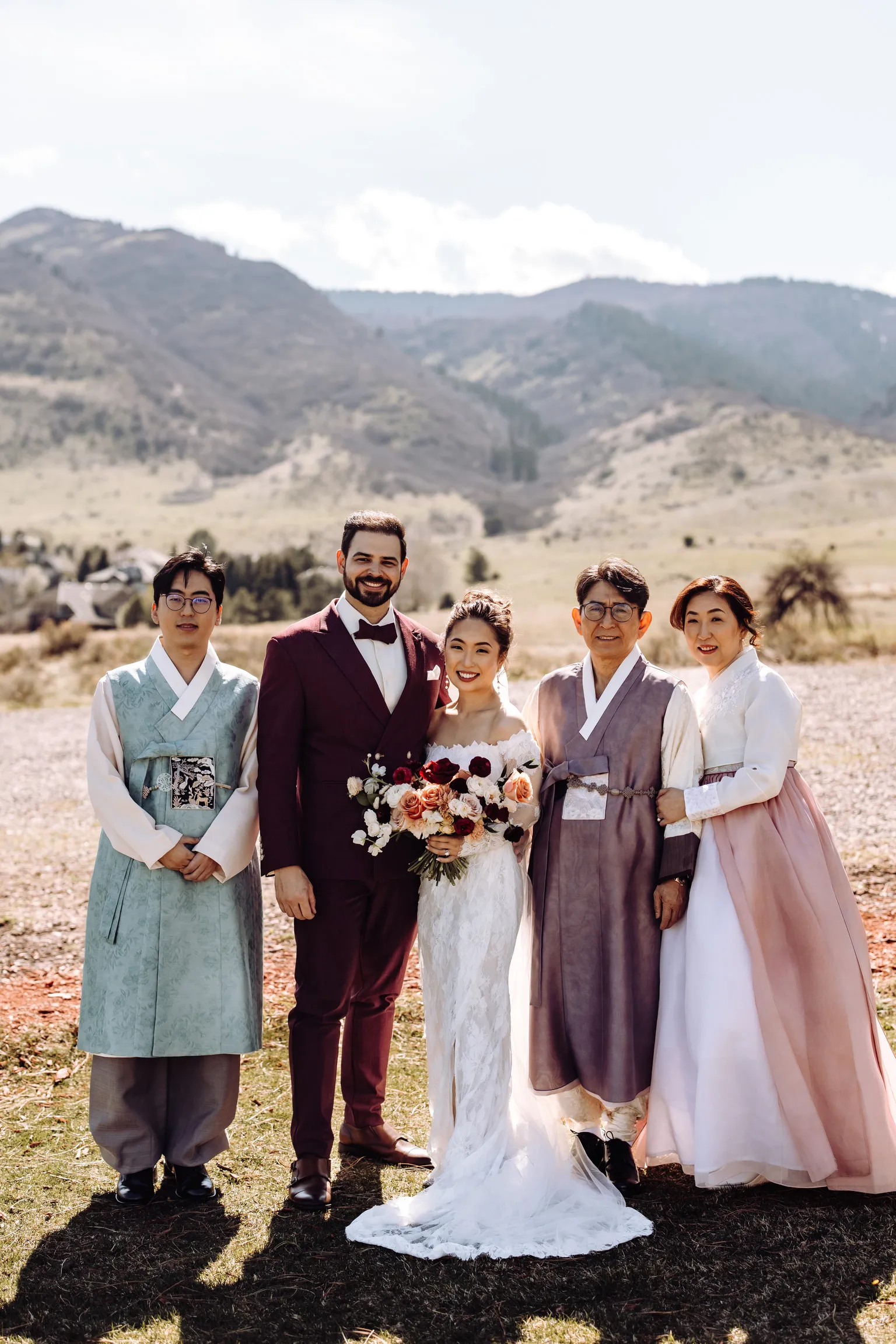 Bride and groom with family in hanbok at The Manor House with mountain views
