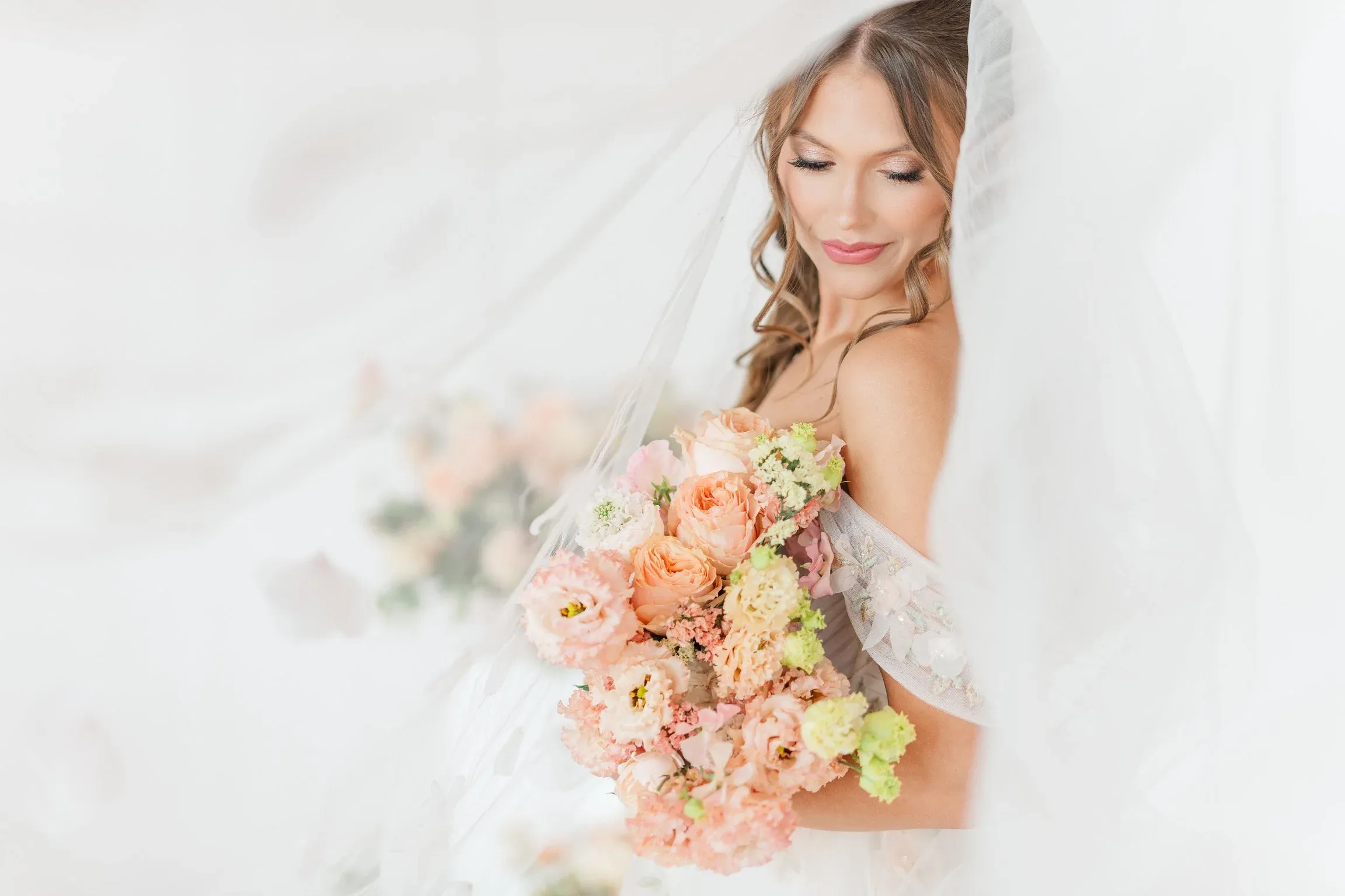 Bride holding a pink, peach, and cream wedding bouquet
