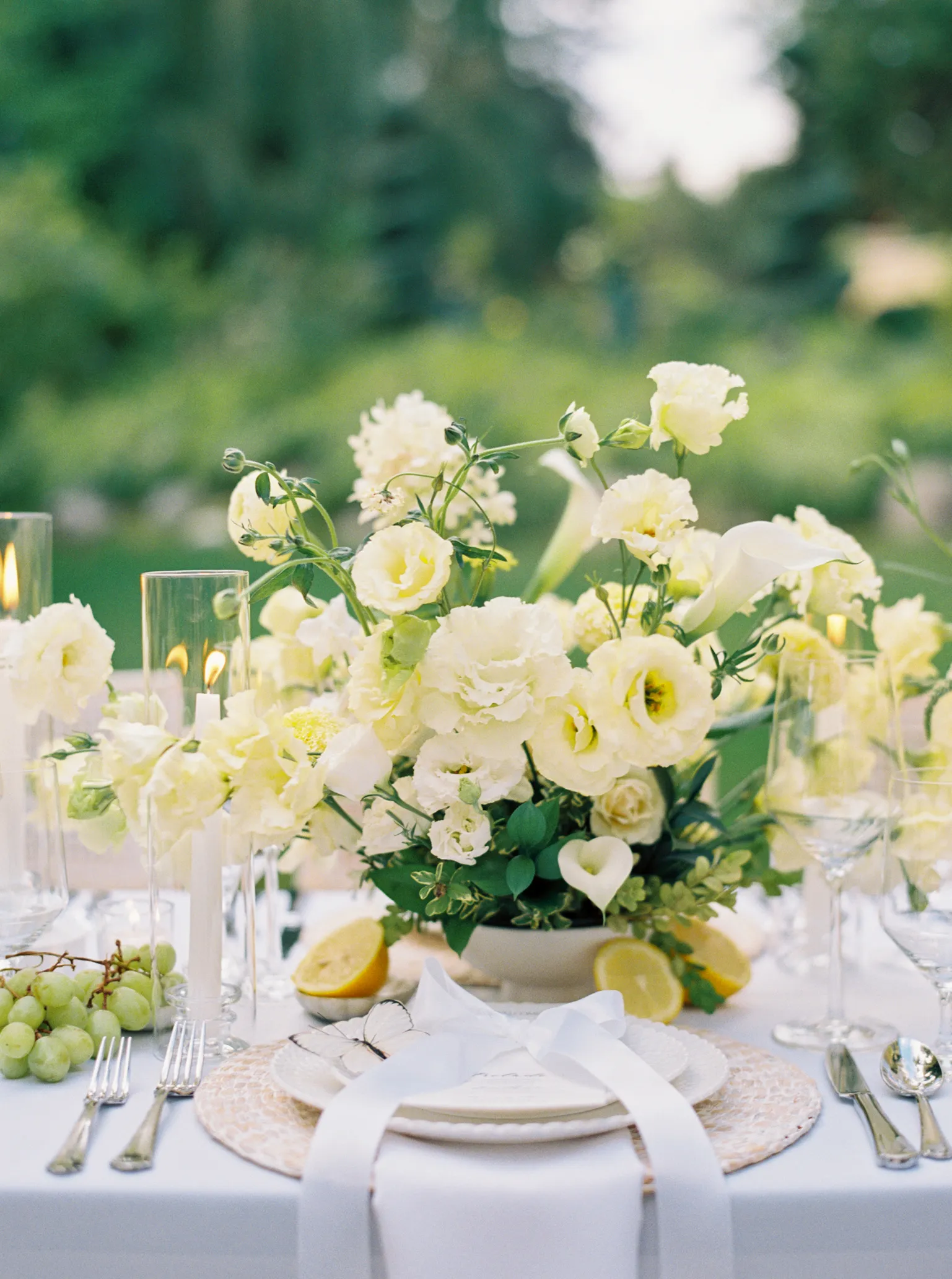 Oceana's Gardens outdoor place setting with white floral centerpiece, candles, and lemons