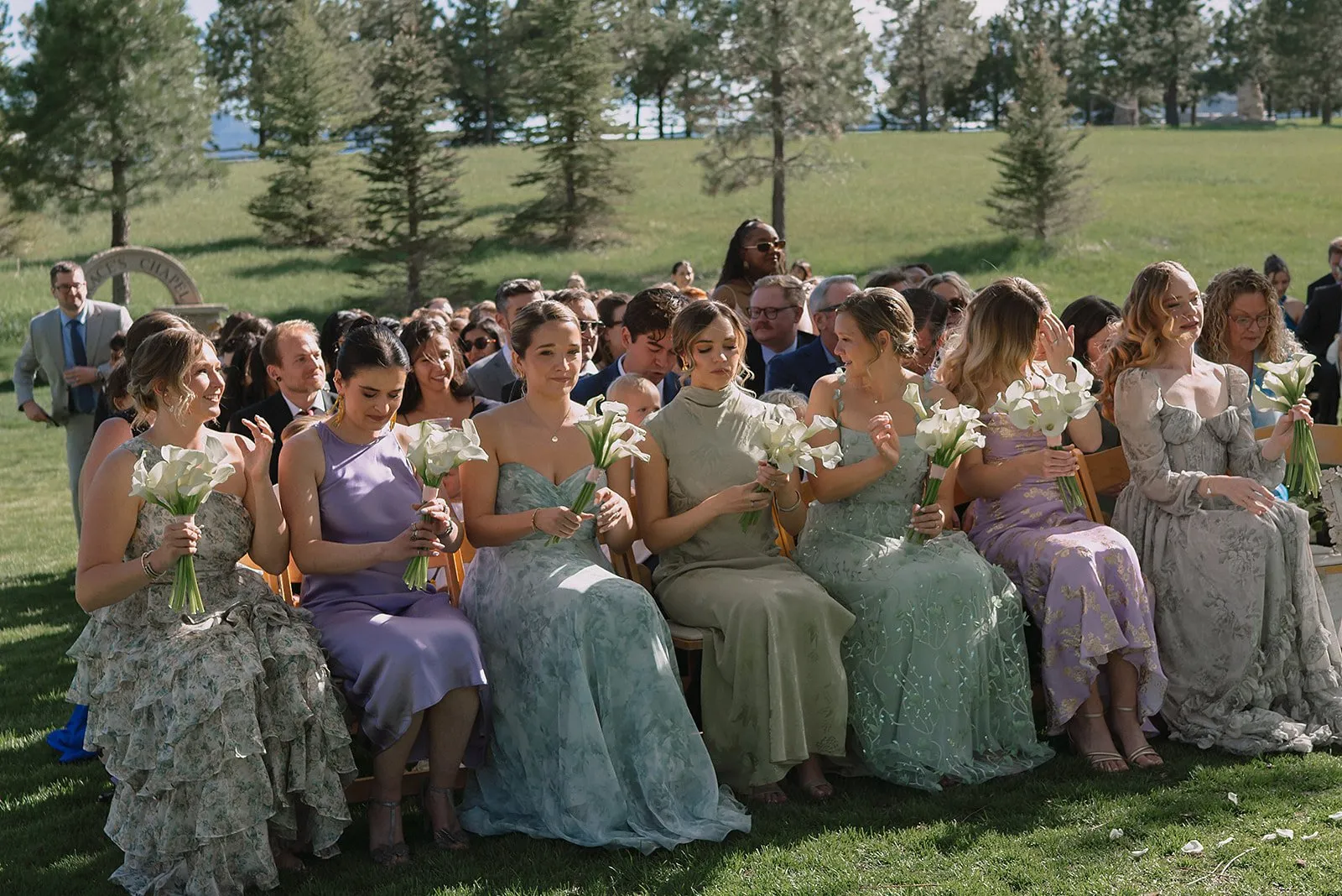 Outdoor wedding ceremony with calla lily bouquets and guests