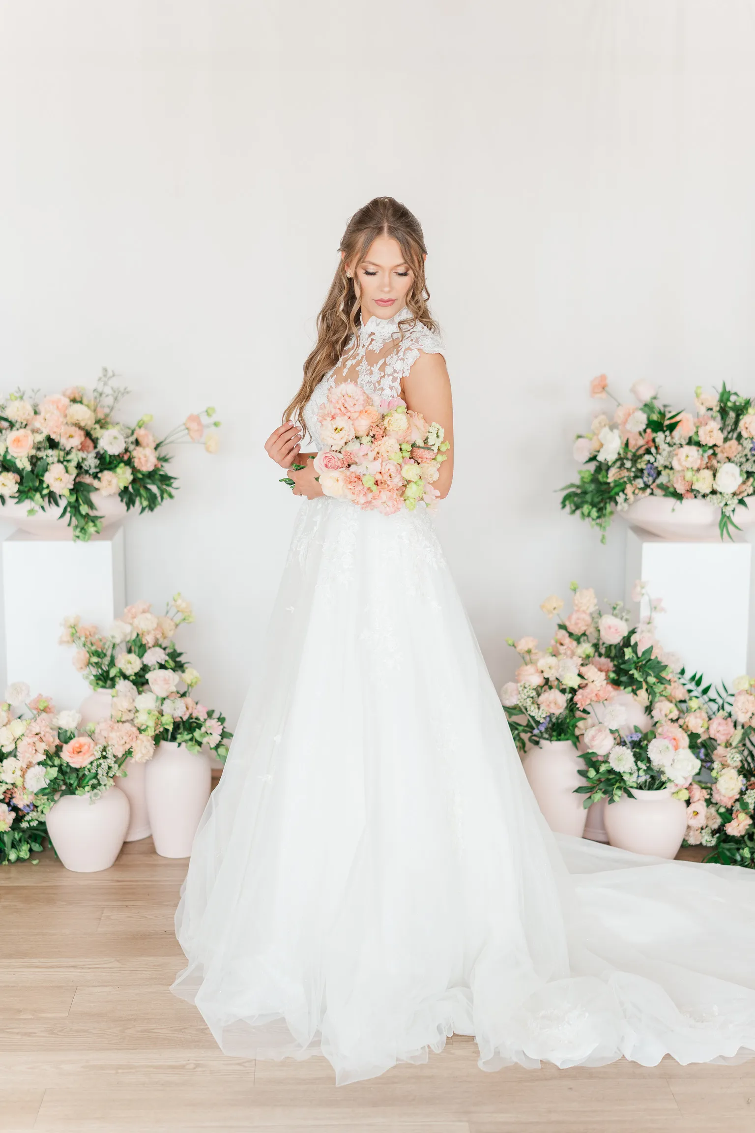 Newlywed couple posing outdoors with a white floral bouquet