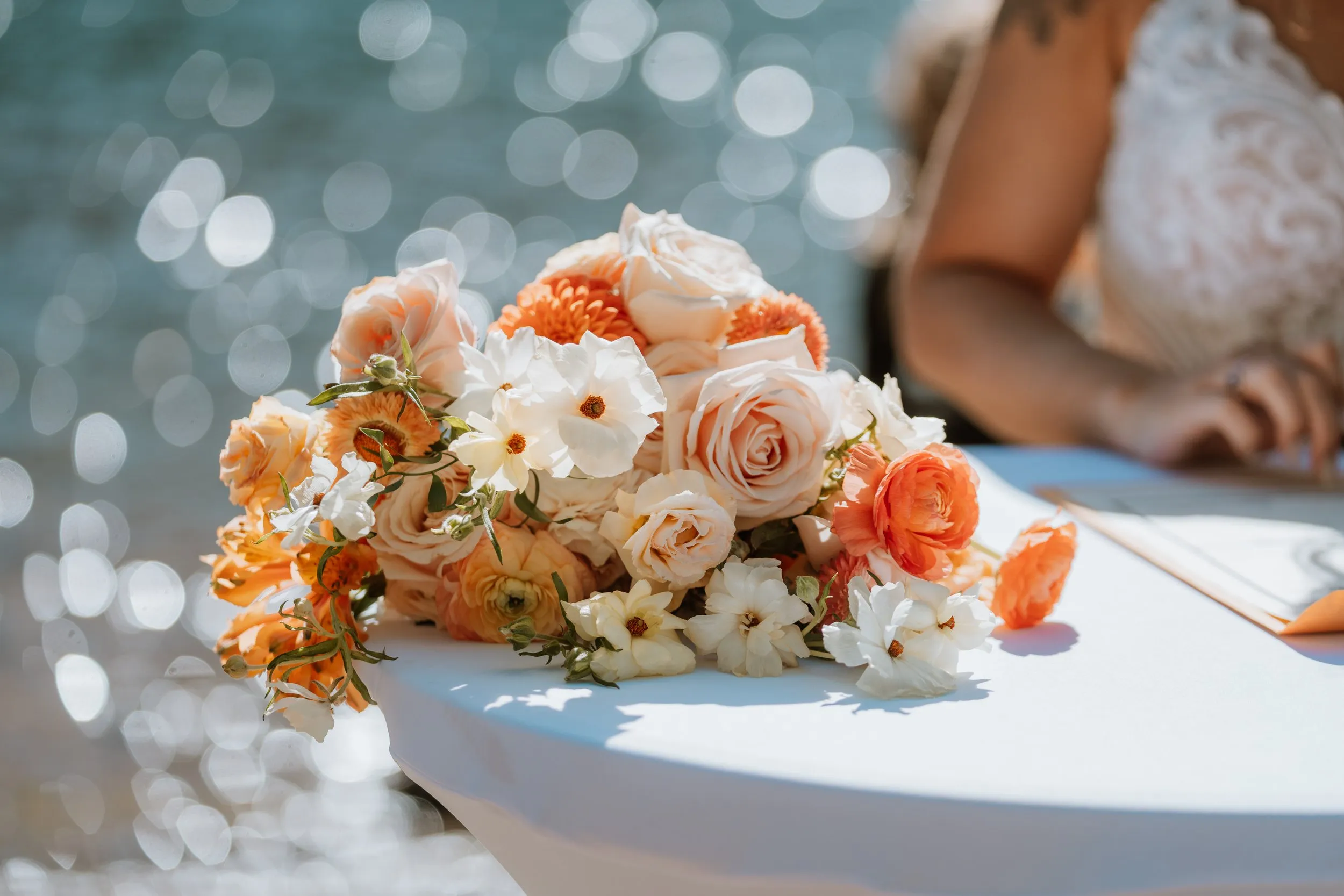 Woods lake wedding with peach, white, and orange bouquet waterside
